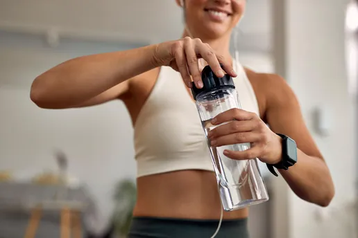 Persona en el gimnasio llenando su botella con agua purificada